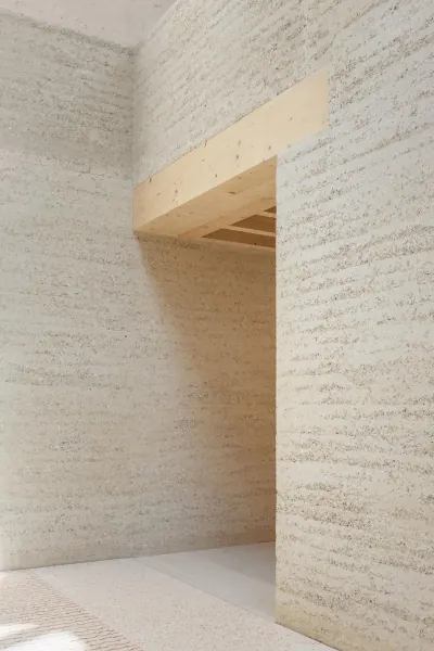 Intérieur aux murs de pisé clair, linteau et plafond de bois